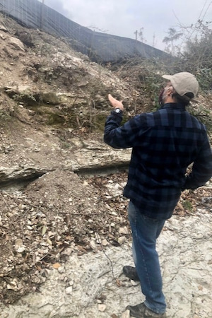 Fouad Jaber of Texas A&M AgriLife Water University points to the creek bank, which he notes was cut too steep by the contractors. Photo by Kristi Kerr Leonard.