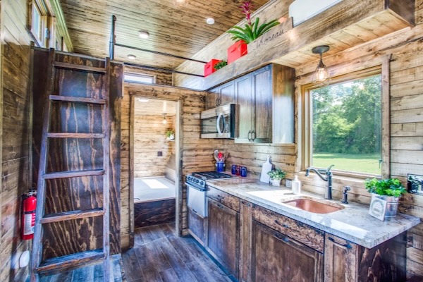 The Thoreau features a ground floor master bedroom and a sleeping loft above that can hold two twin beds. Courtesy of Indigo River Tiny Homes.