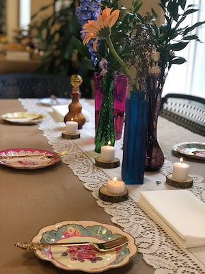 Tablecloths were created from recycled paper. Thrift-store vases  filled with locally-sourced flowers served as centerpieces. Photo by Marjorie Lombard