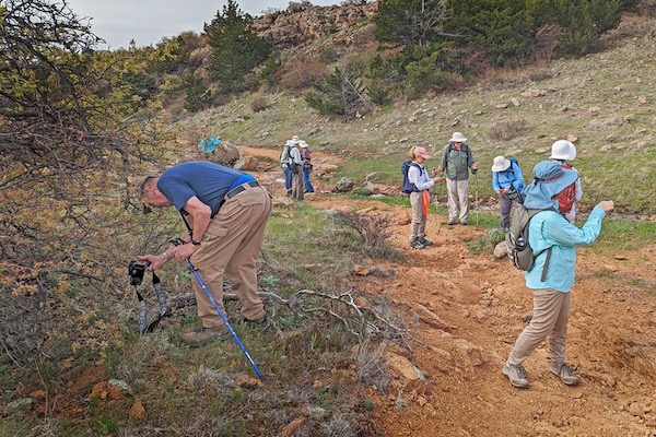 Jeff Quayle, left, finds something interesting while leading a plant survey in Wichita Mountains Wildlife Refuge in Oklahoma this spring. Photo by J.G. Domke.