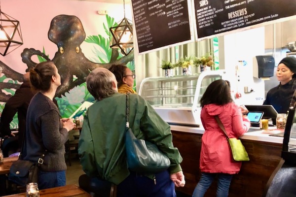 TLC Vegan's to-go business is brisk with after-work crowd grabbing food for enjoying at home. Photo by Amy Martin. 